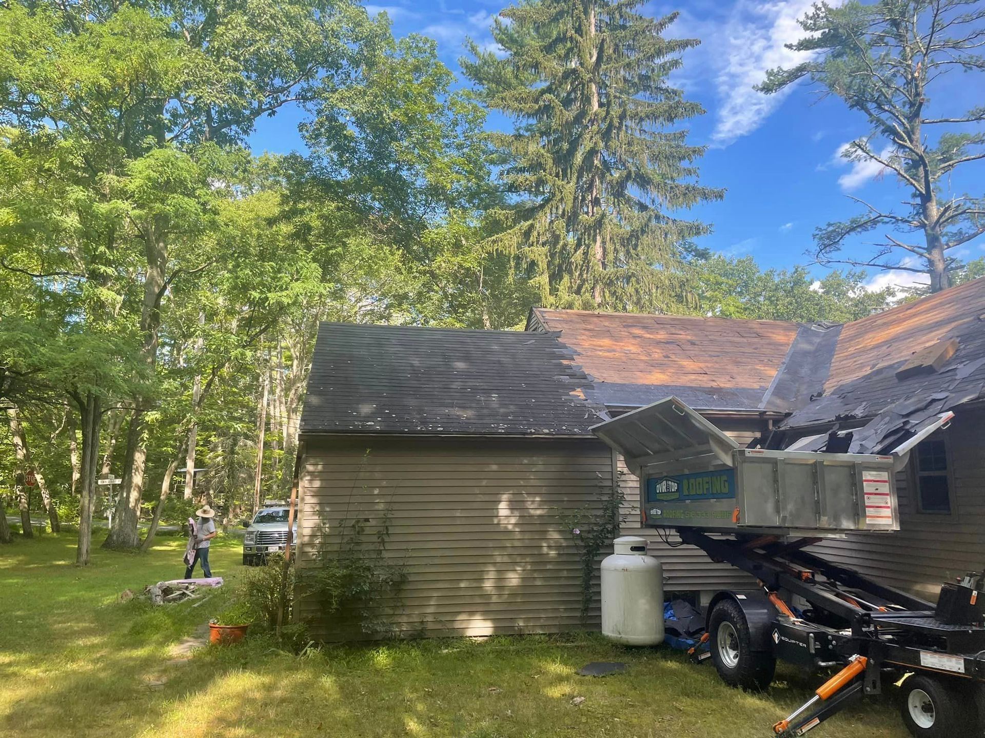 A dumpster is parked in front of a house.