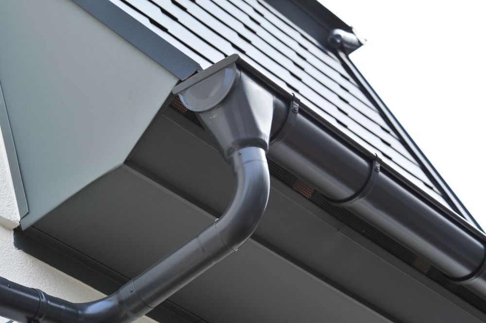 A black gutter on the side of a building