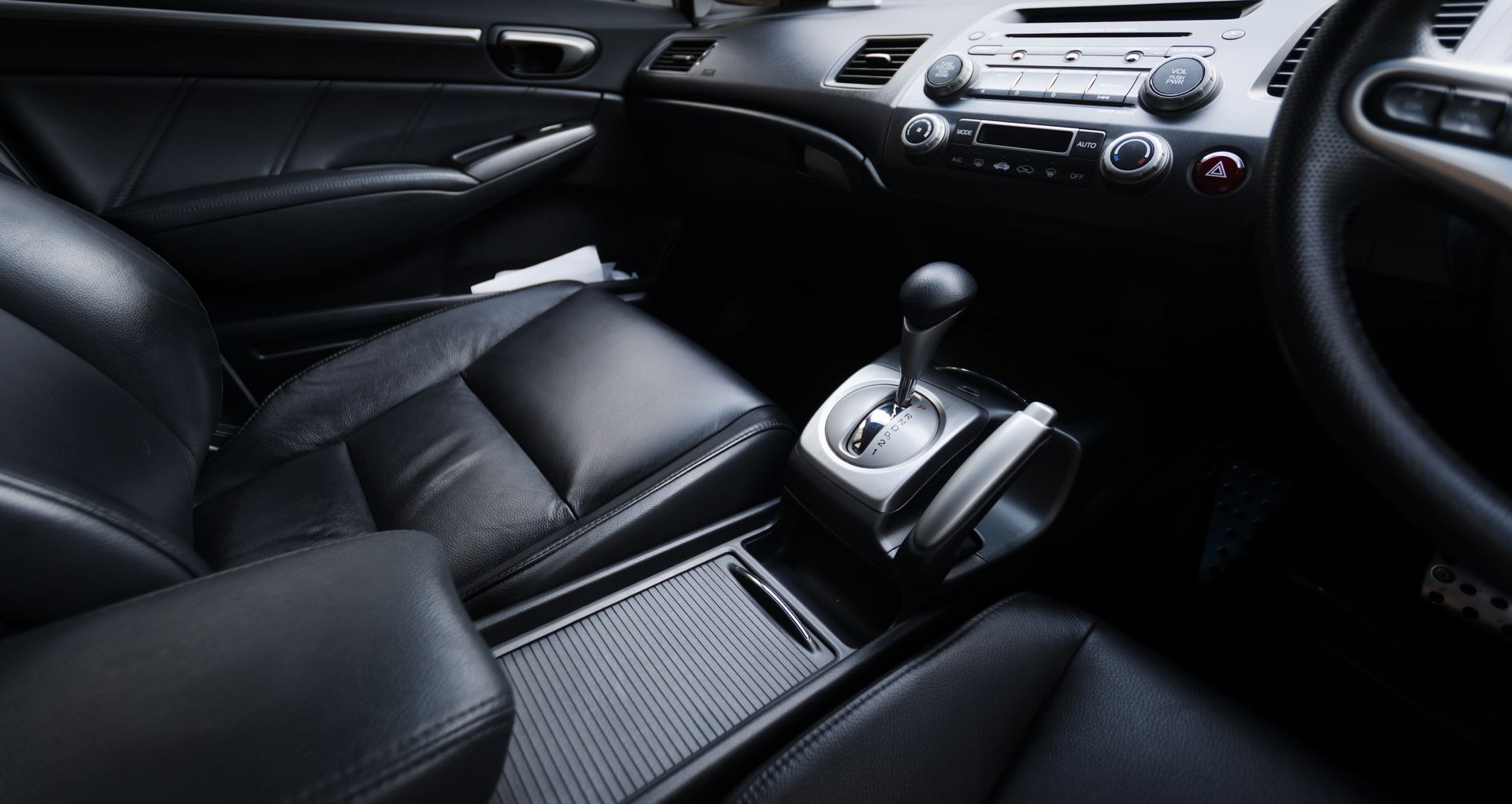 The interior of a car with black leather seats and a steering wheel