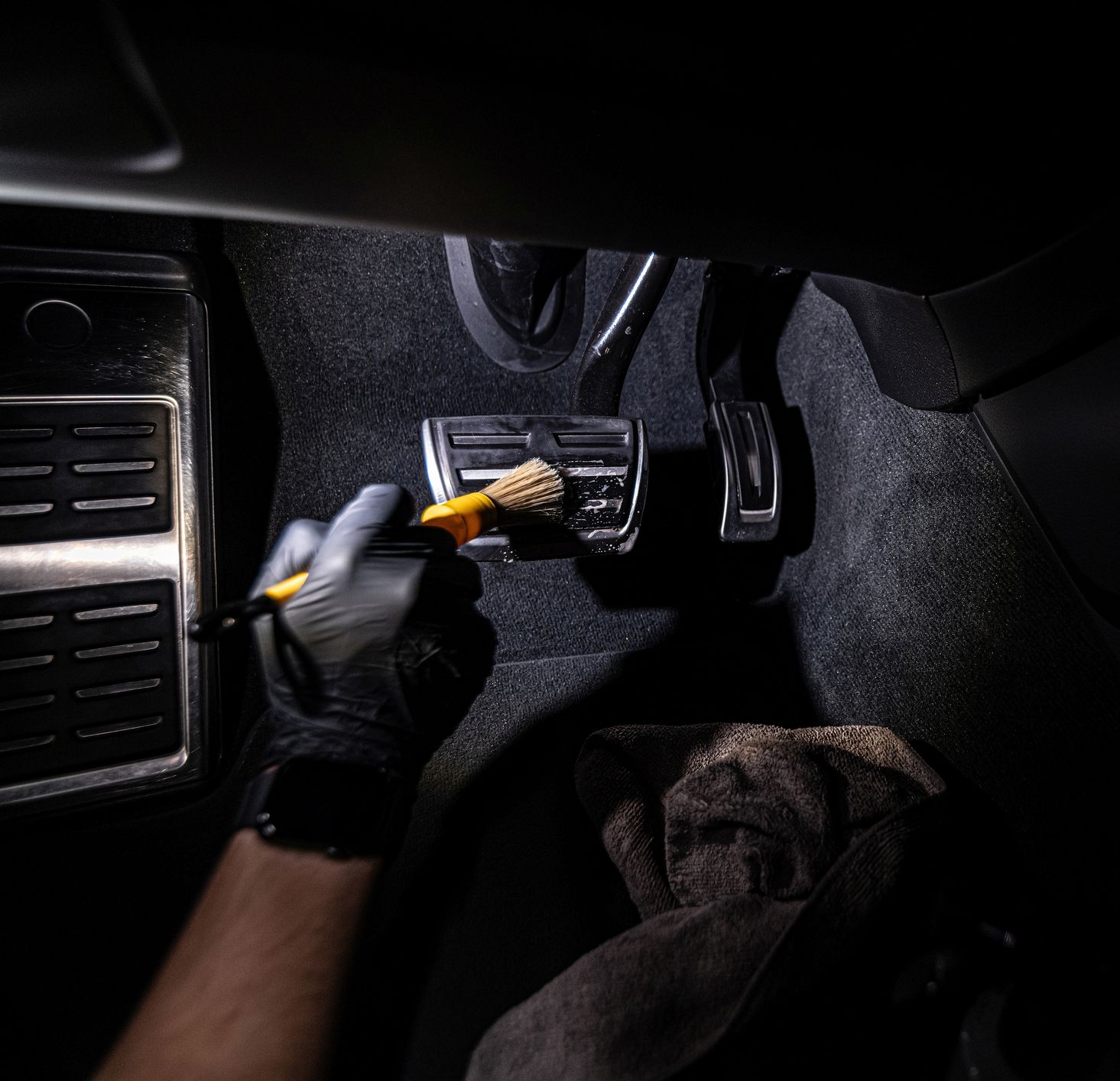 A person is cleaning a car with a brush