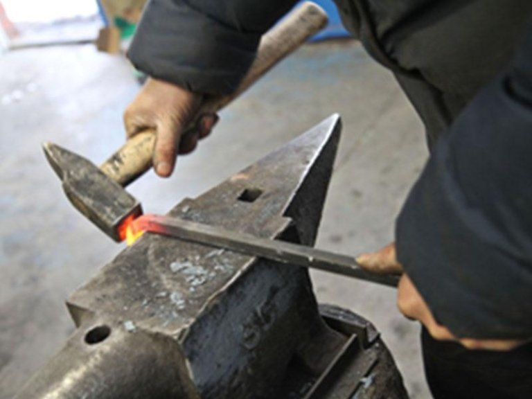 Piegatura del ferro con incudine e martello