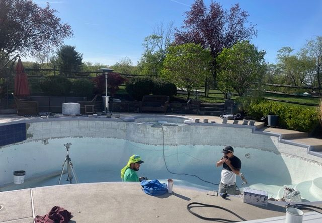 A dark, reflective pond with a brick border. Some leaves float on the surface.