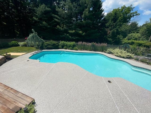 Round blue tiled pool with water, bordered by red brick.