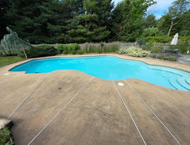 Pool tiles with water cascading over them. Blue and white tiles with diamond pattern at the top, light blue water.