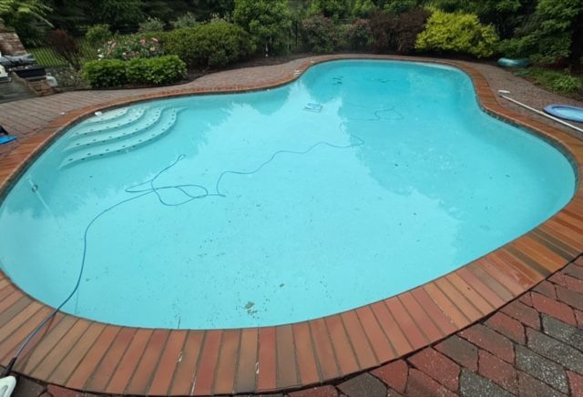 Pool tiles with water cascading over them. Blue and white tiles with diamond pattern at the top, light blue water.