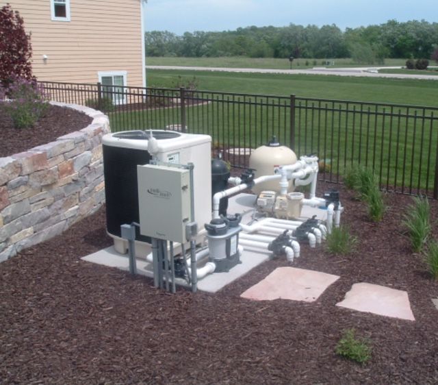 Swimming pool with blue water and stone edging on a sunny day.