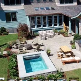 Backyard patio with a small pool, seating area, and dining table. Home exterior in the background.