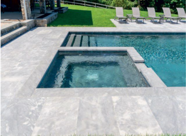 Round pool with blue tiled sides, water, and brick edge.