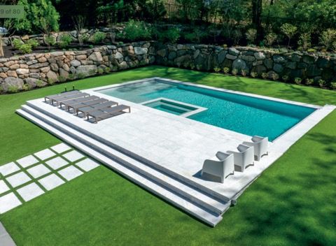 Pool with a dark blue interior, surrounded by light concrete patio.