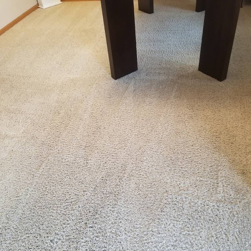 A carpeted floor with a table in the background