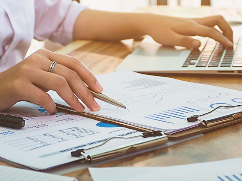 Asmuo rašo nešiojamuoju kompiuteriu.