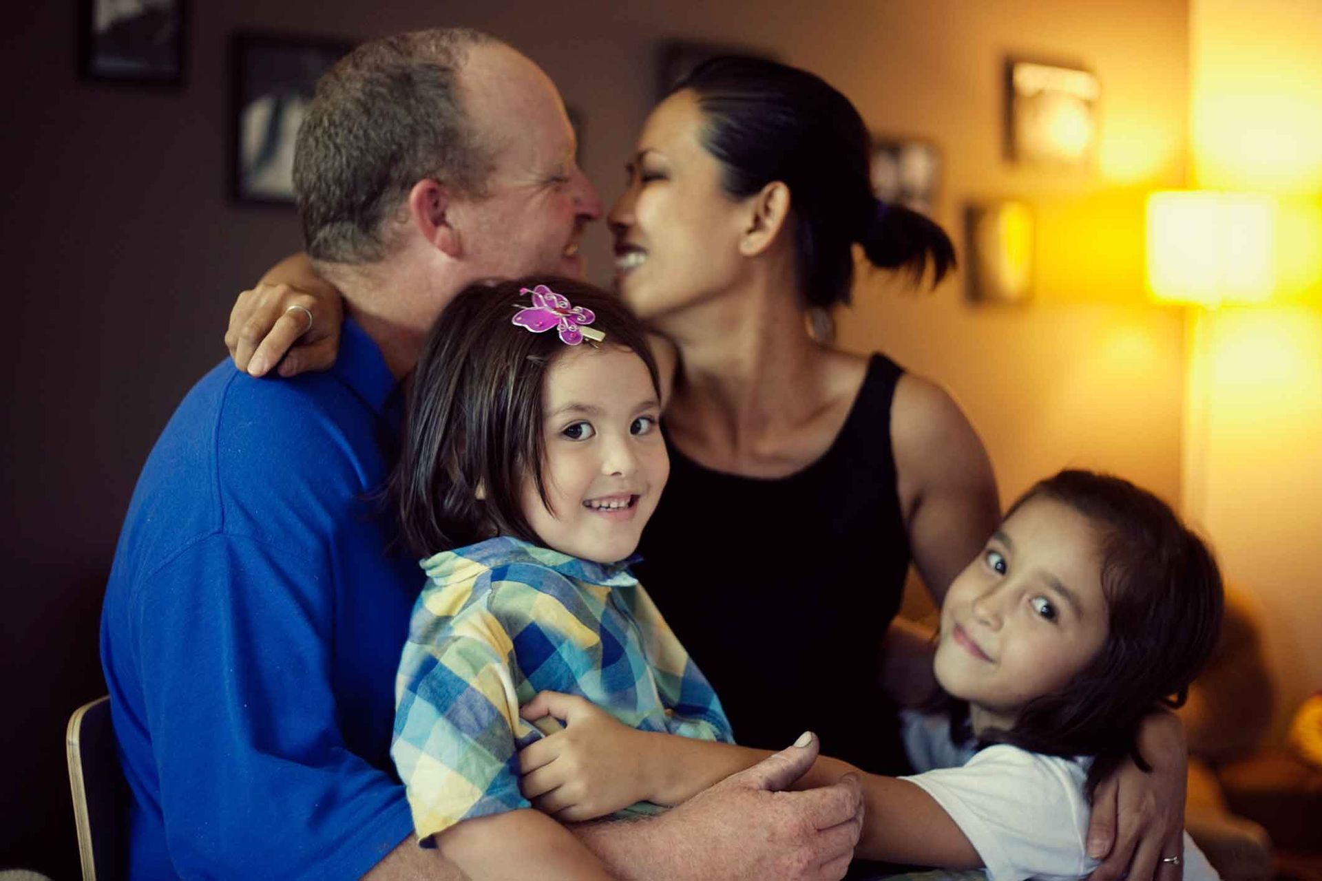 A family is posing for a picture together in a living room.