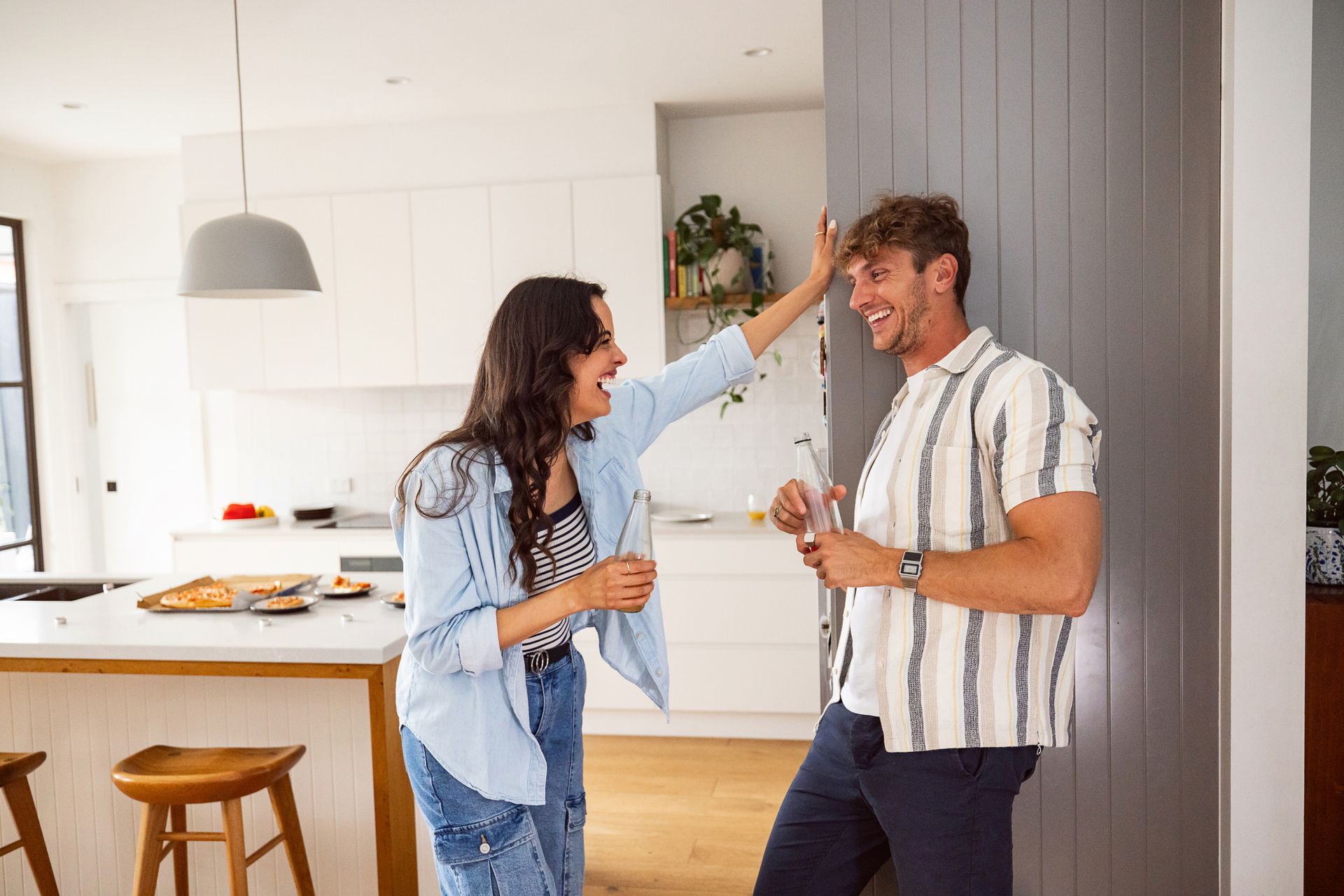 A man and a woman are standing next to each other in a kitchen.