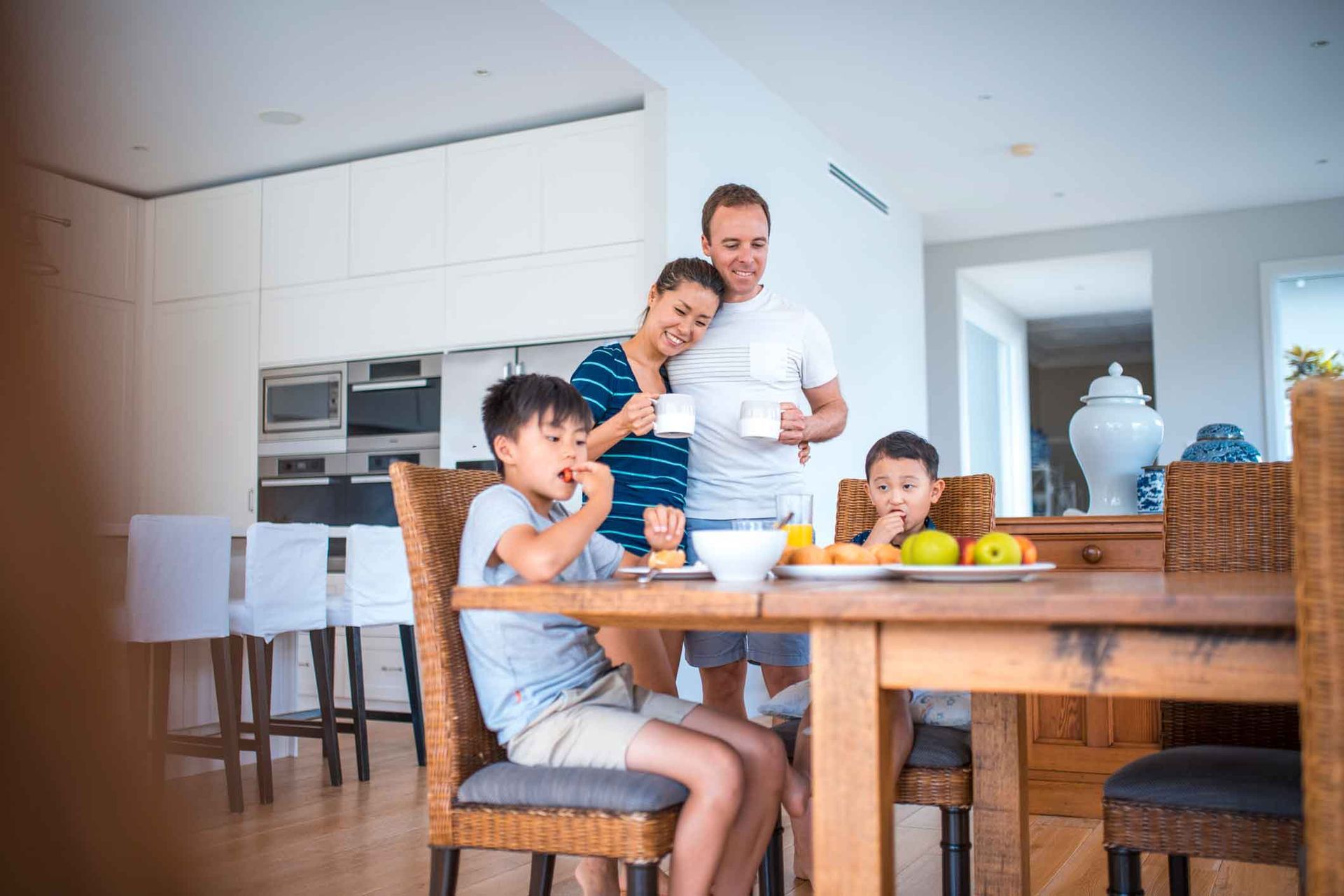 A family is sitting at a table eating breakfast together.