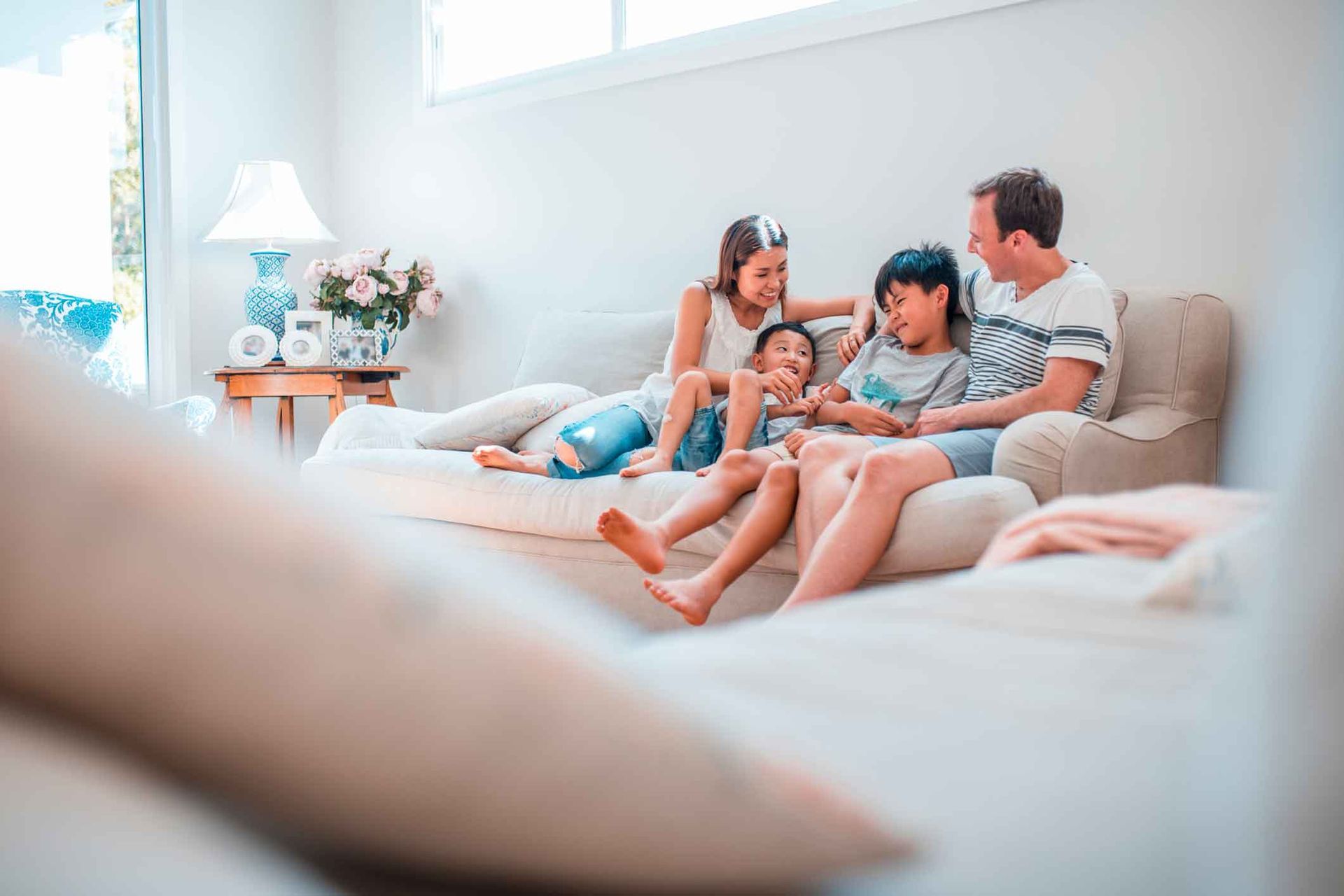 A family is sitting on a couch in a living room.
