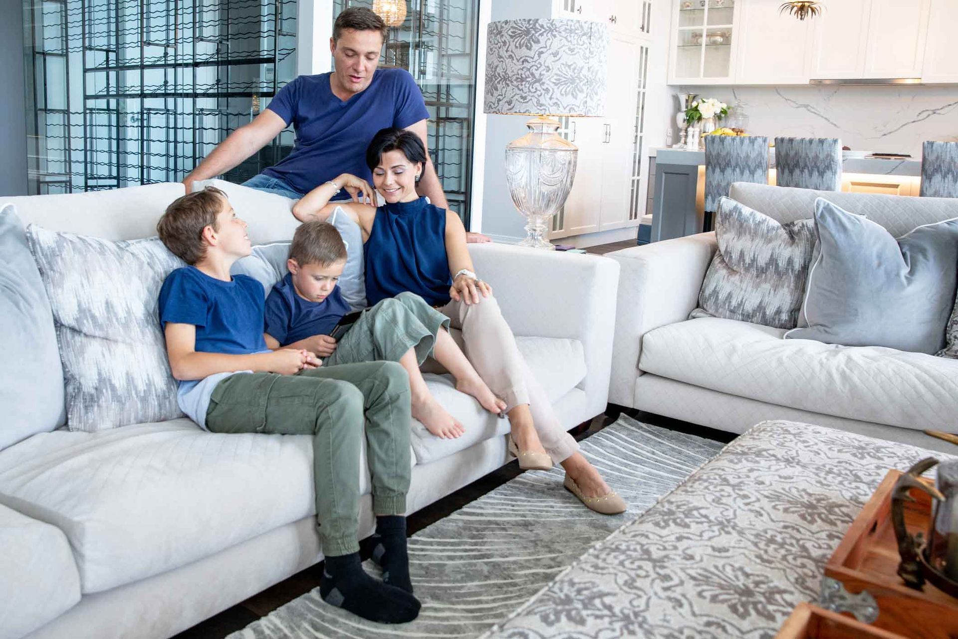 A family is sitting on a couch in a living room.