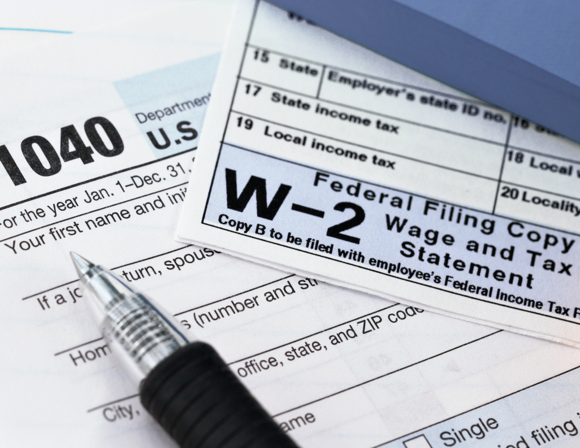 A pen sits on top of a 1040 tax form
