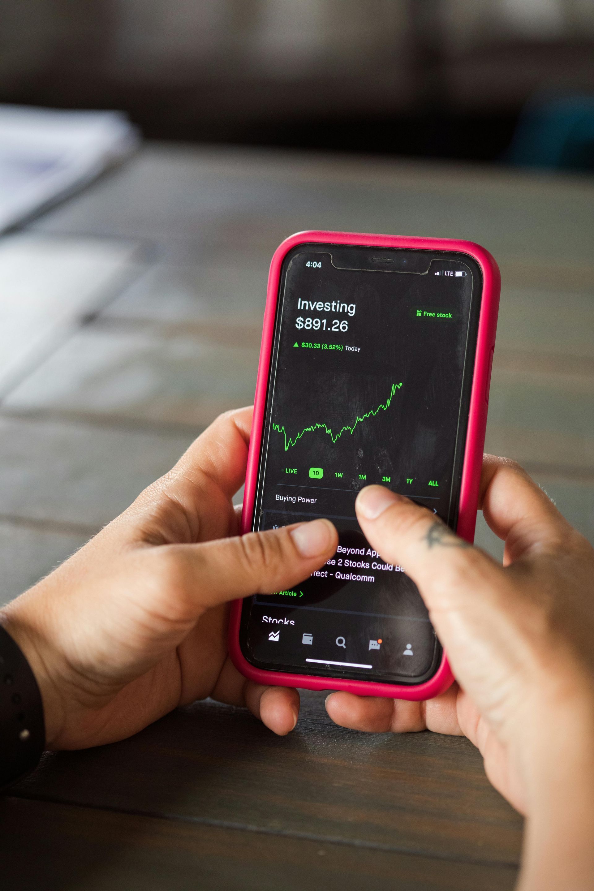 A person is holding a cell phone with a graph on it.