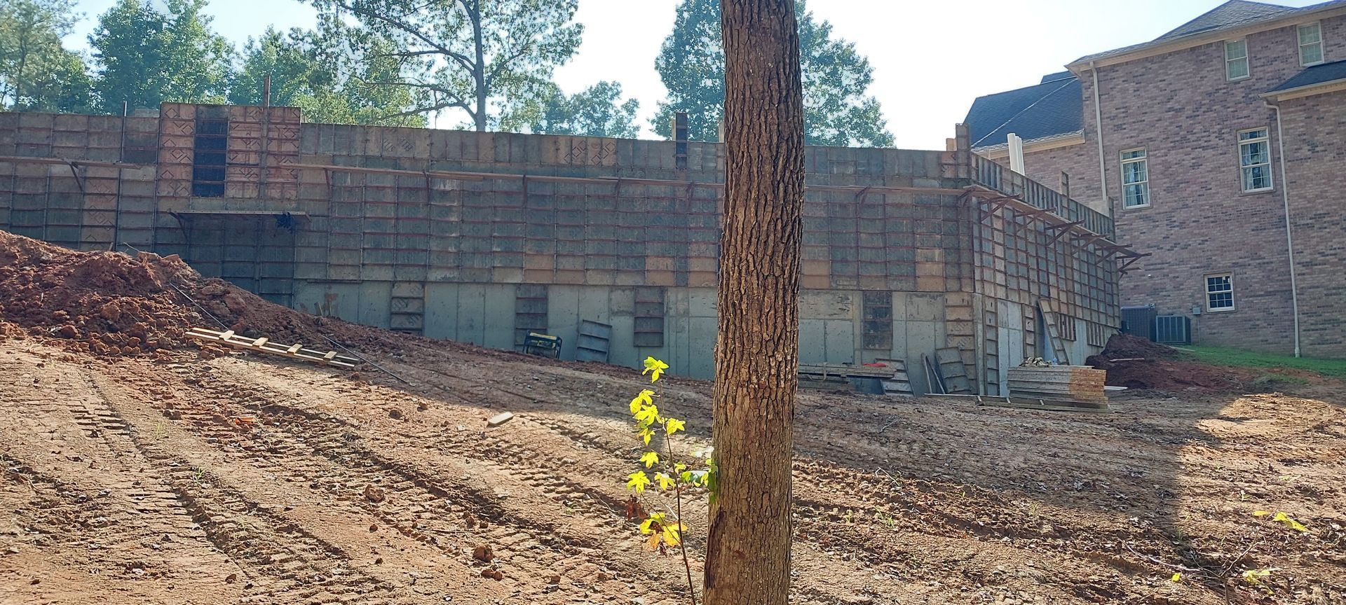 A large pile of dirt is sitting in front of a building under construction.