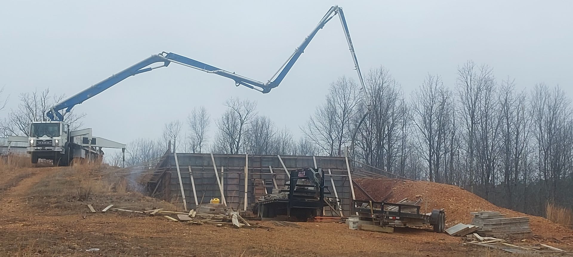 A concrete pump is being used to pour concrete into a building under construction.