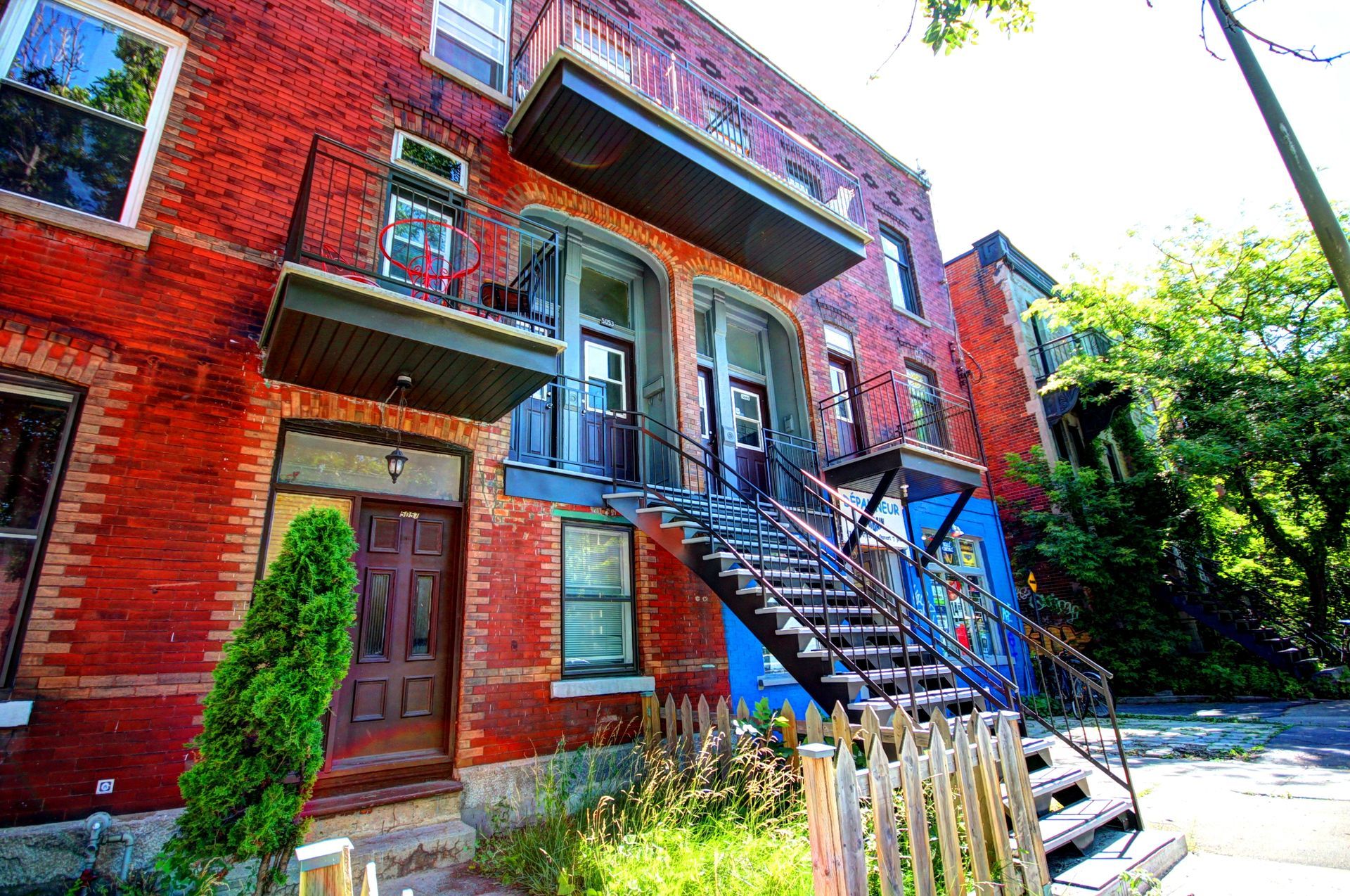 Un immeuble en brique rouge avec des escaliers menant au deuxième étage