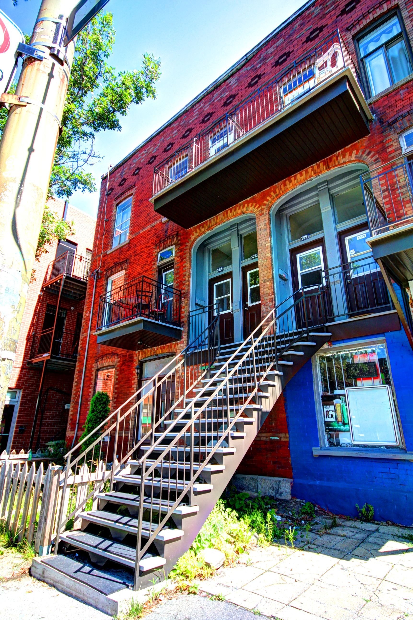 Un immeuble en brique avec des escaliers menant au deuxième étage