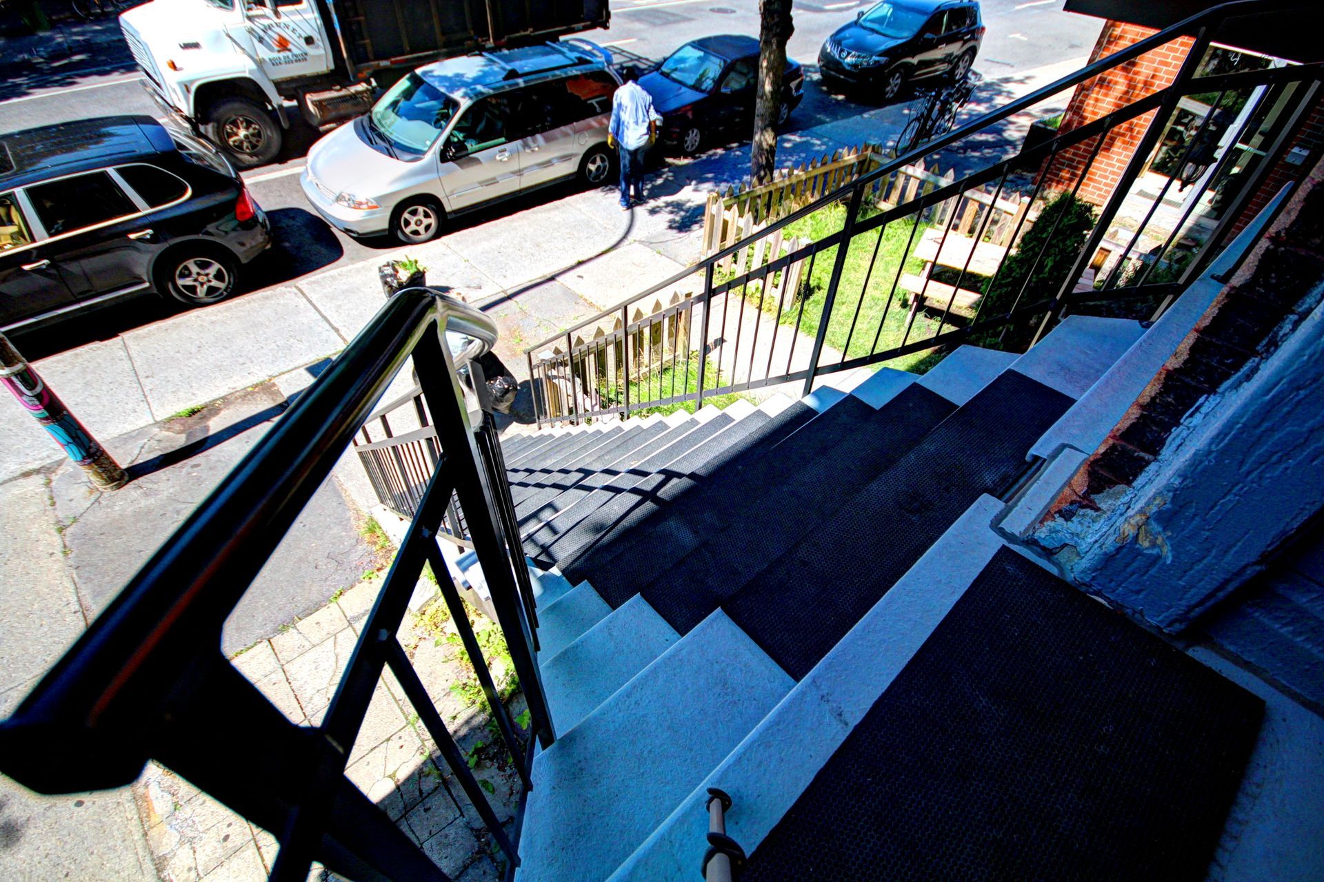 Escaliers menant à un bâtiment avec des voitures garées sur le bord de la route