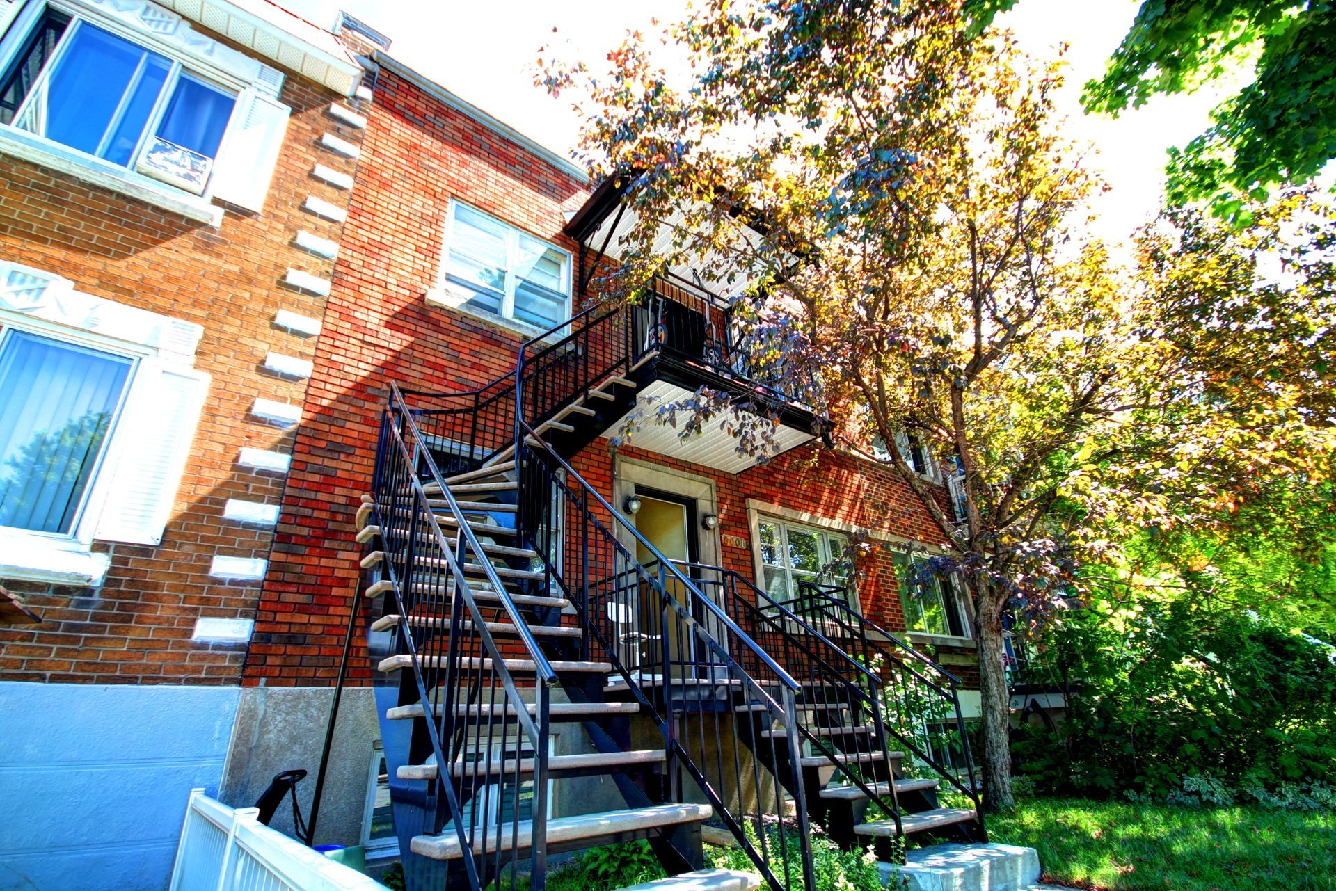 Une maison en brique avec des escaliers menant au deuxième étage