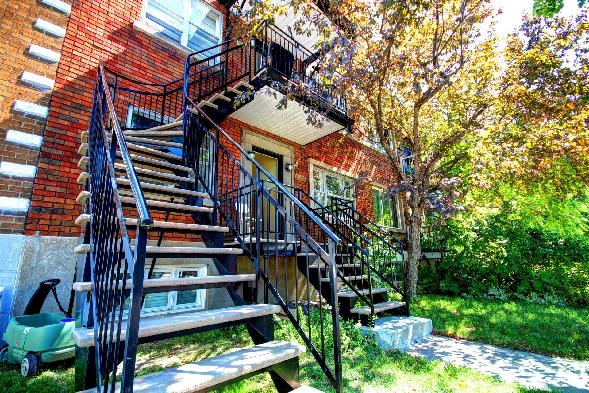 Un escalier menant au deuxième étage d'un immeuble en brique.