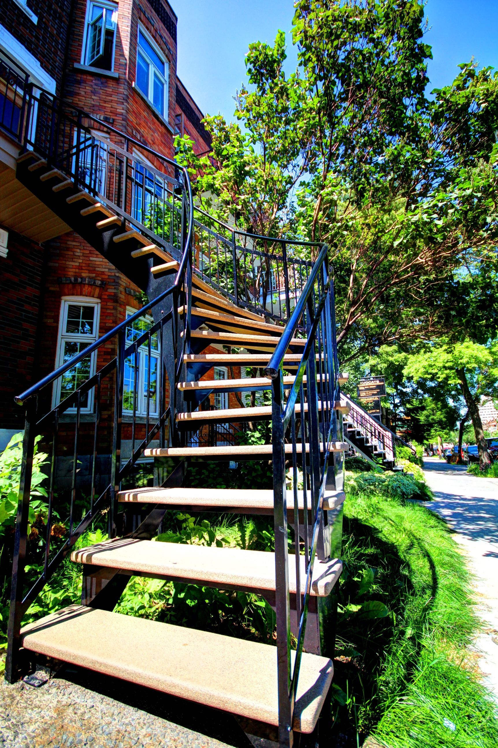 Un escalier en bois menant à un bâtiment en brique
