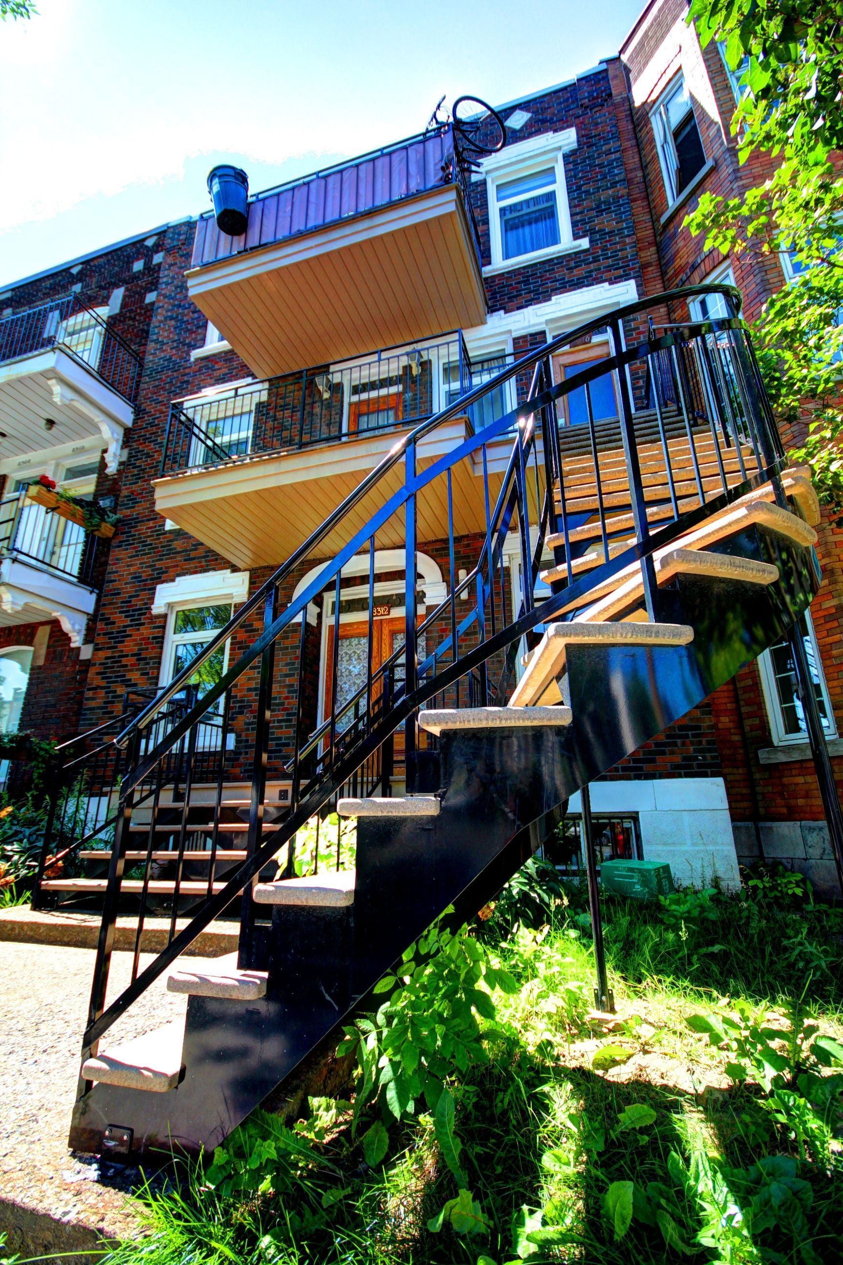 Un immeuble en brique avec des escaliers menant au deuxième étage