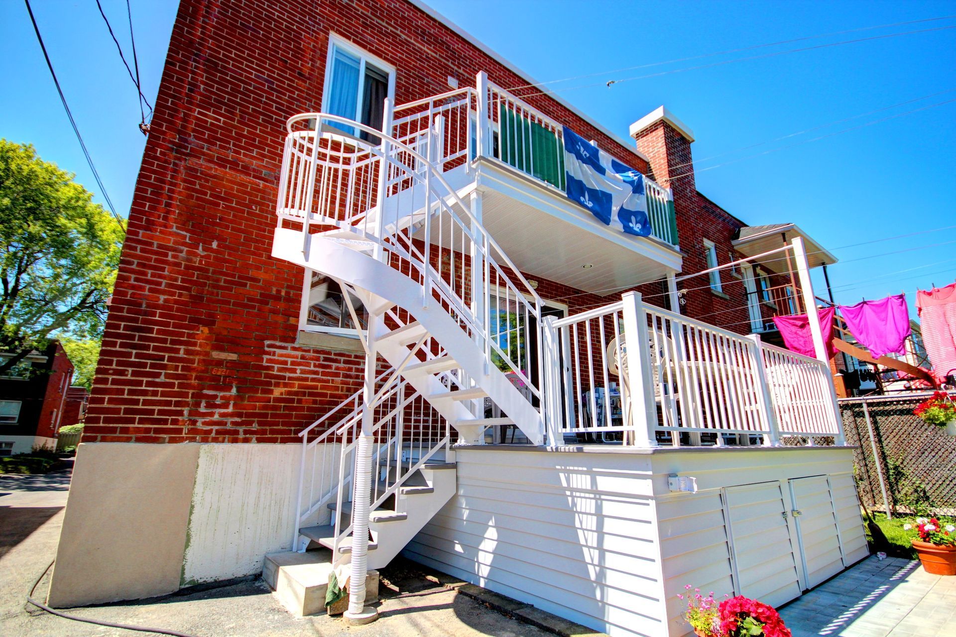 Un bâtiment en brique avec un escalier blanc menant à un balcon.