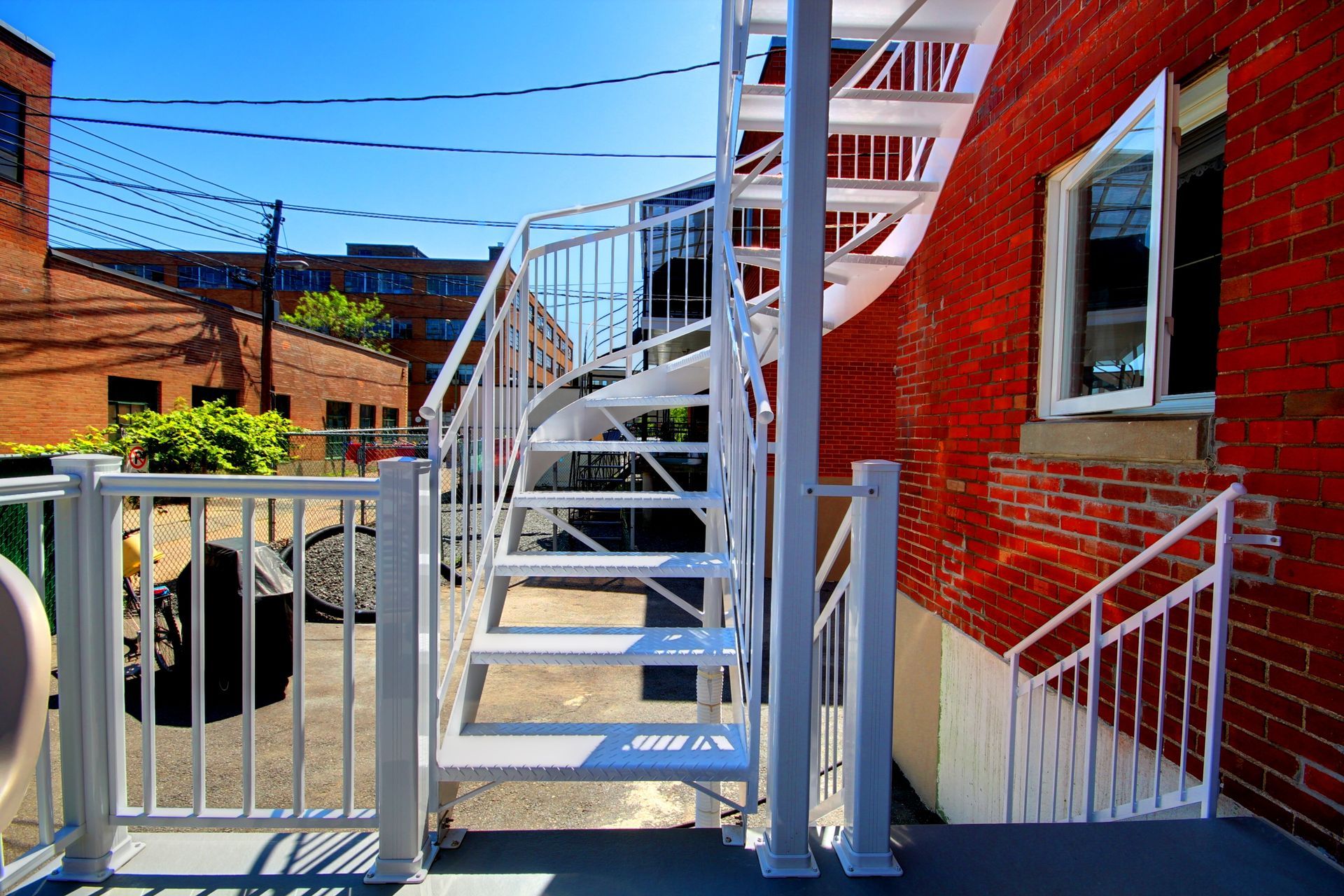 Un escalier blanc menant à un bâtiment en brique