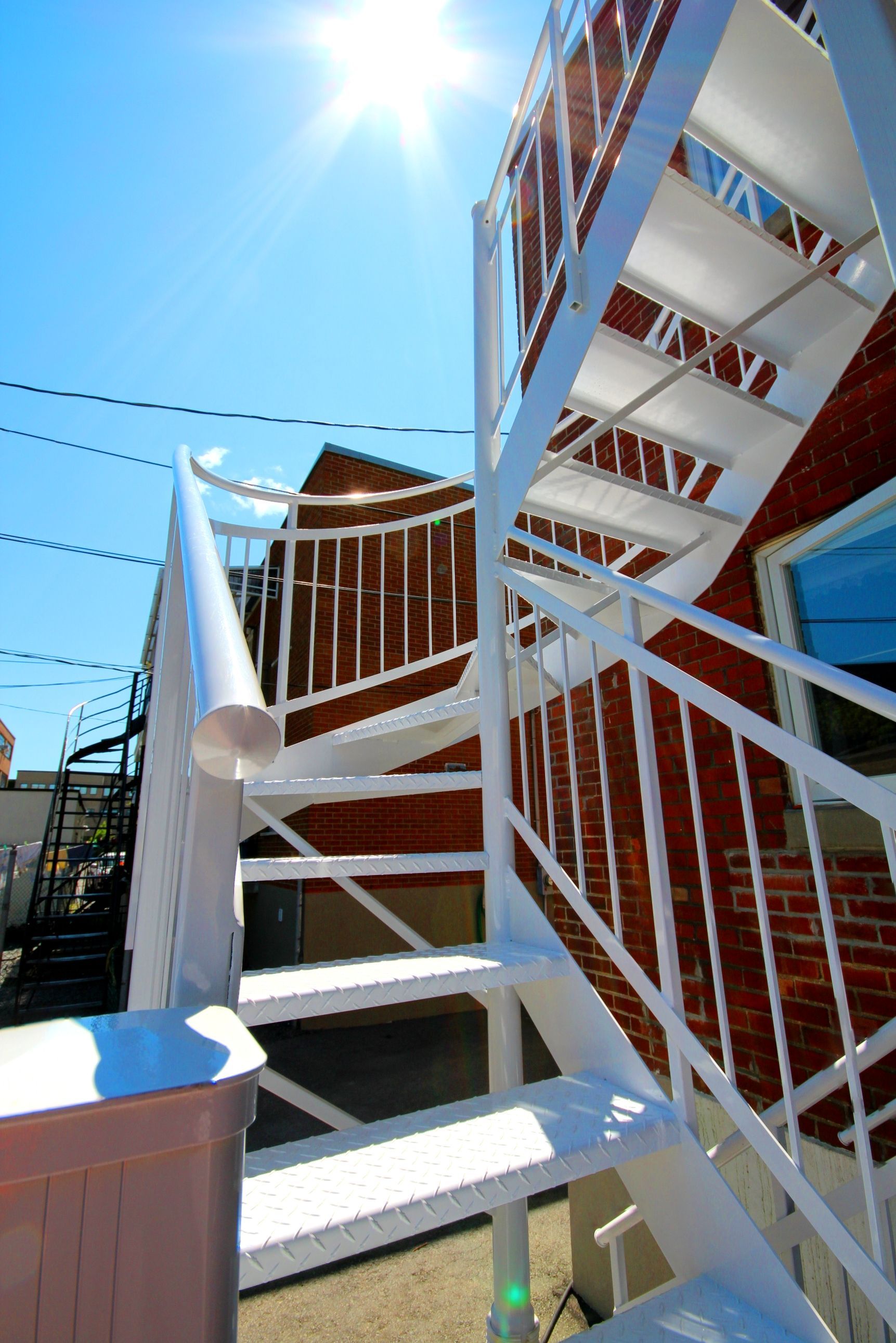 Un escalier blanc menant à un bâtiment en brique