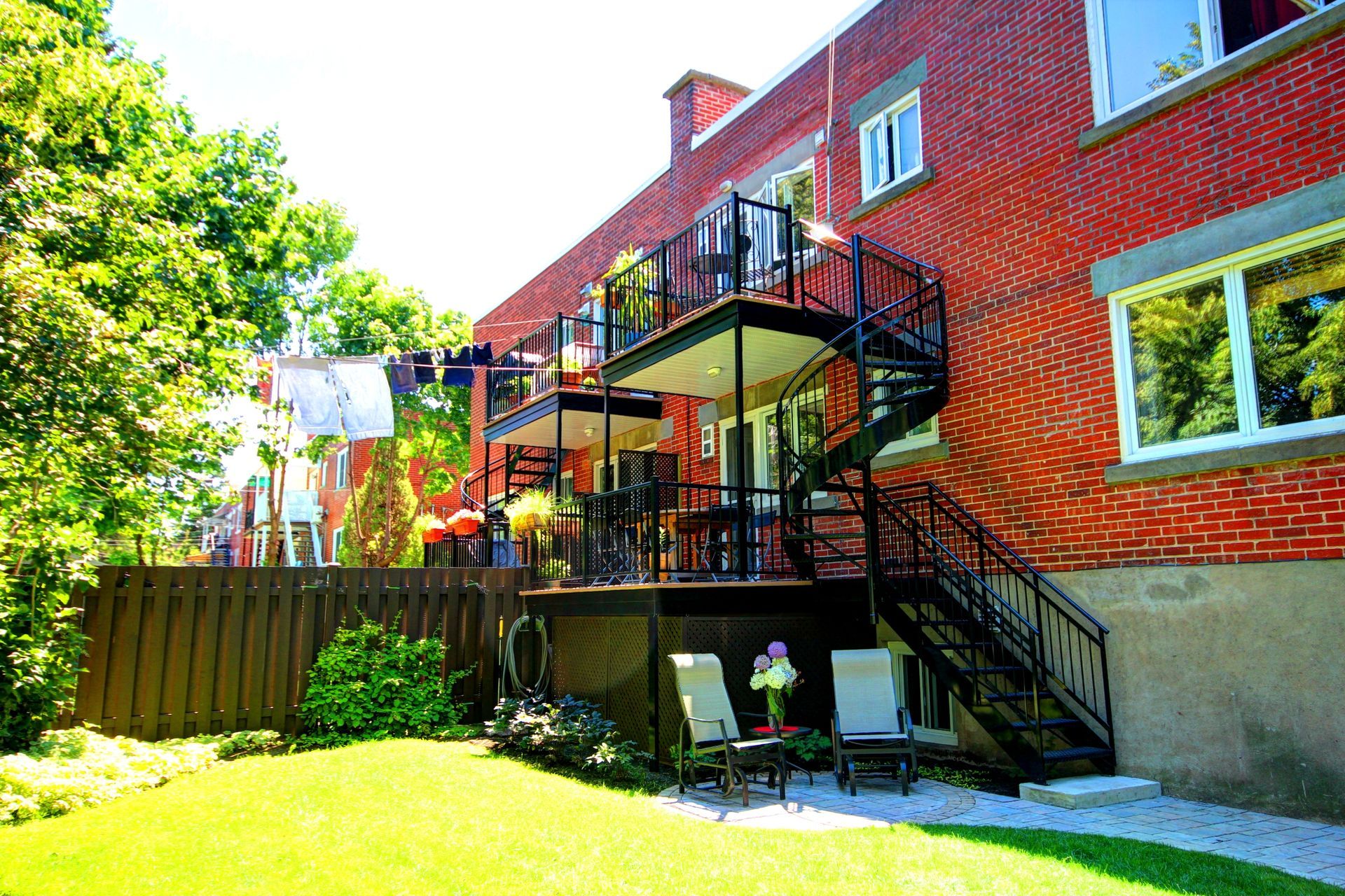 Une maison en brique avec une terrasse et des escaliers dans la cour