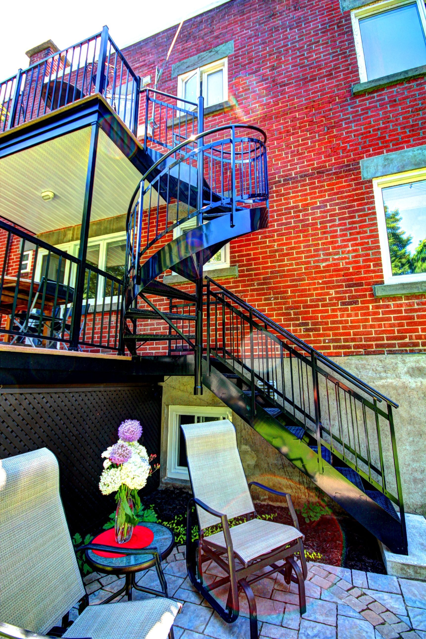 Il y a un escalier en colimaçon menant au deuxième étage d'un immeuble en brique.