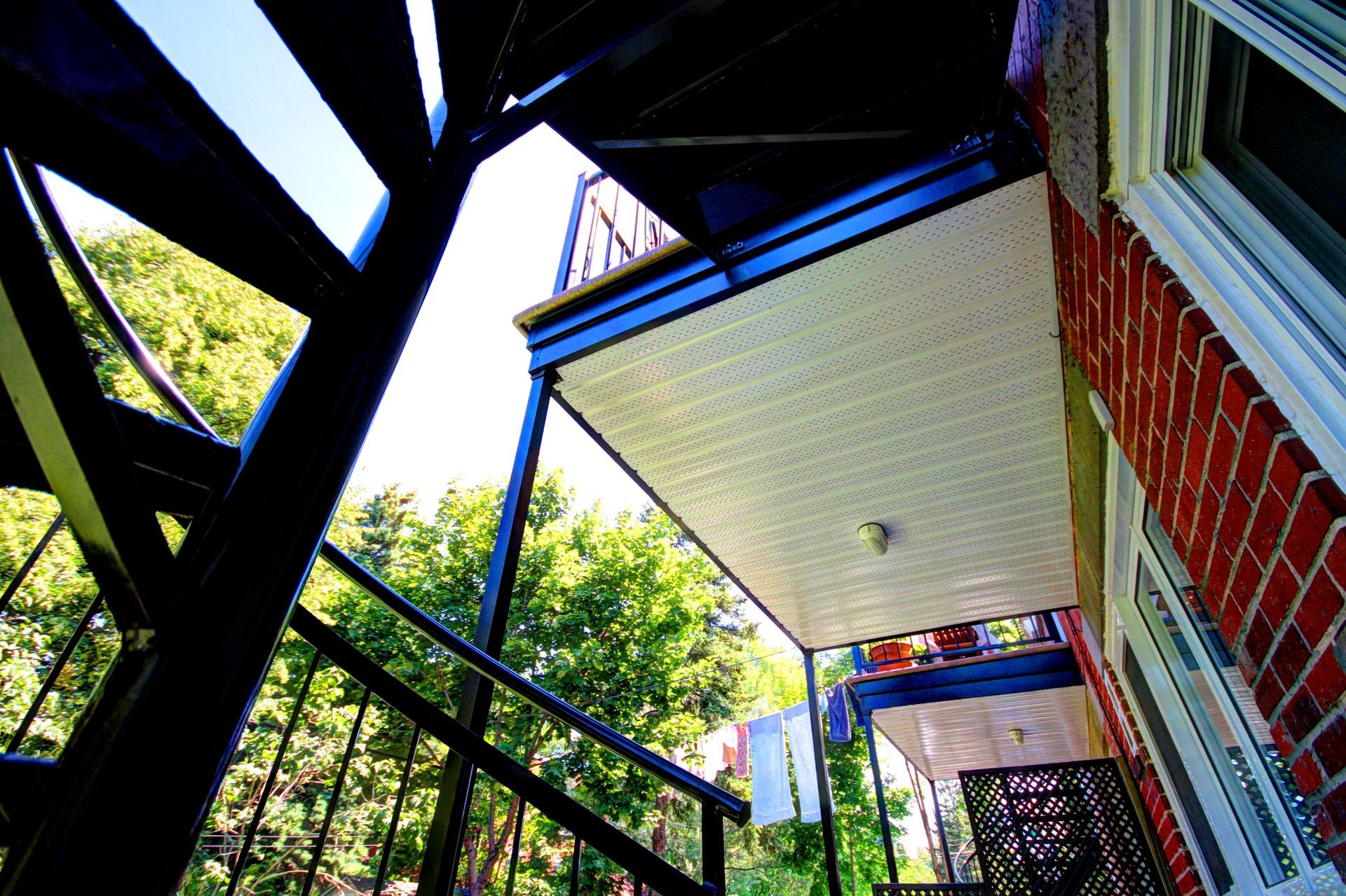 Un bâtiment en brique avec un balcon et des escaliers qui y mènent