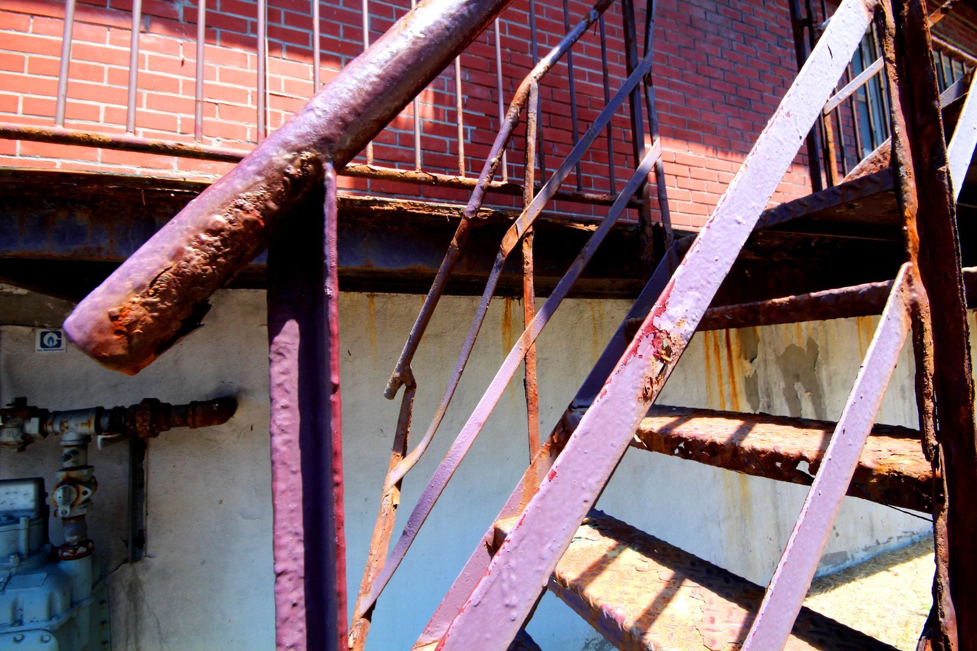 Un escalier en métal rouillé avec un mur de briques en arrière-plan