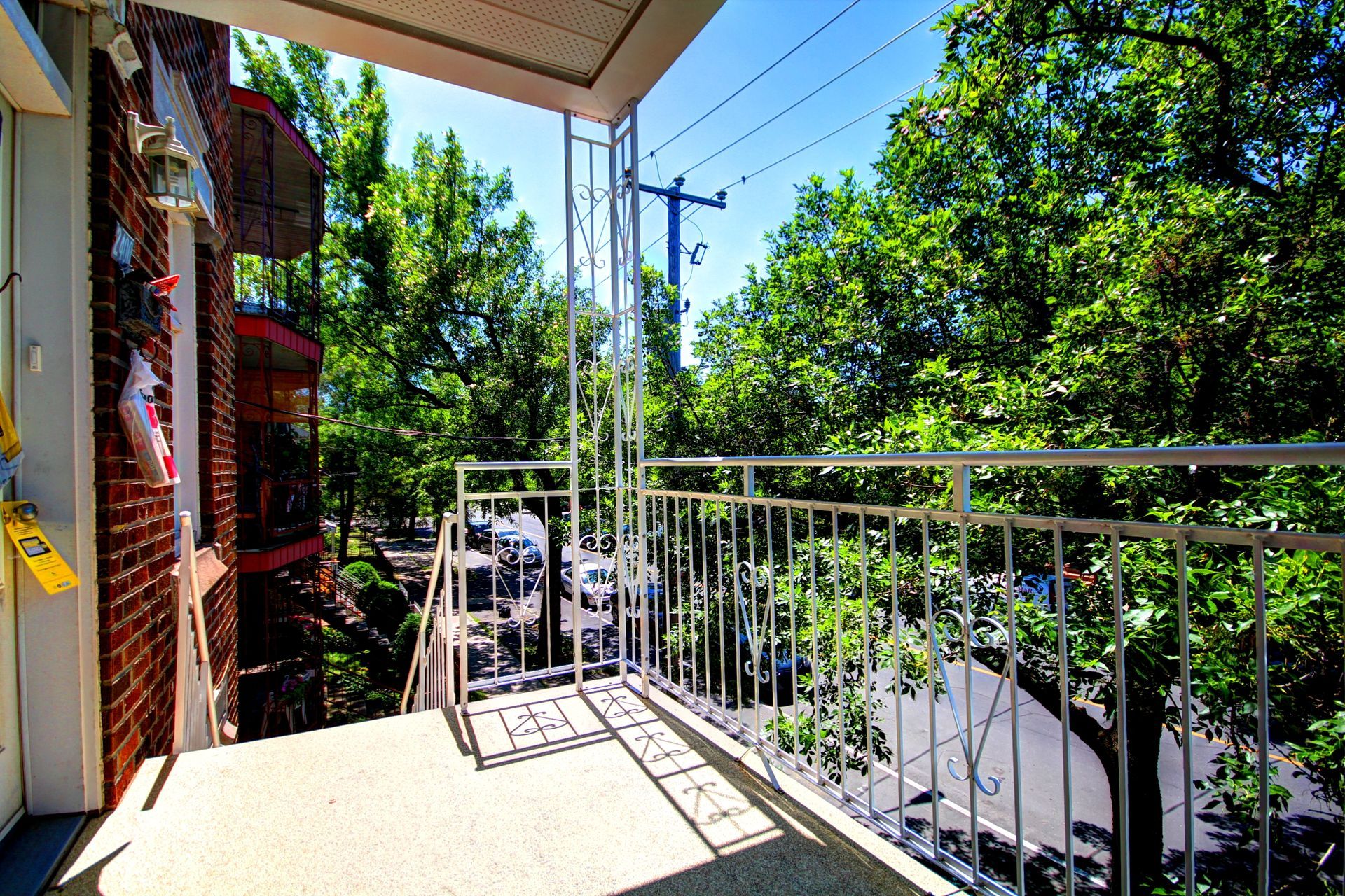 Un balcon avec une balustrade en métal et des arbres en arrière-plan