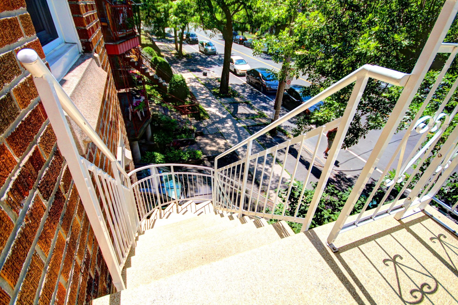 Un escalier menant à un bâtiment en brique avec une balustrade blanche.