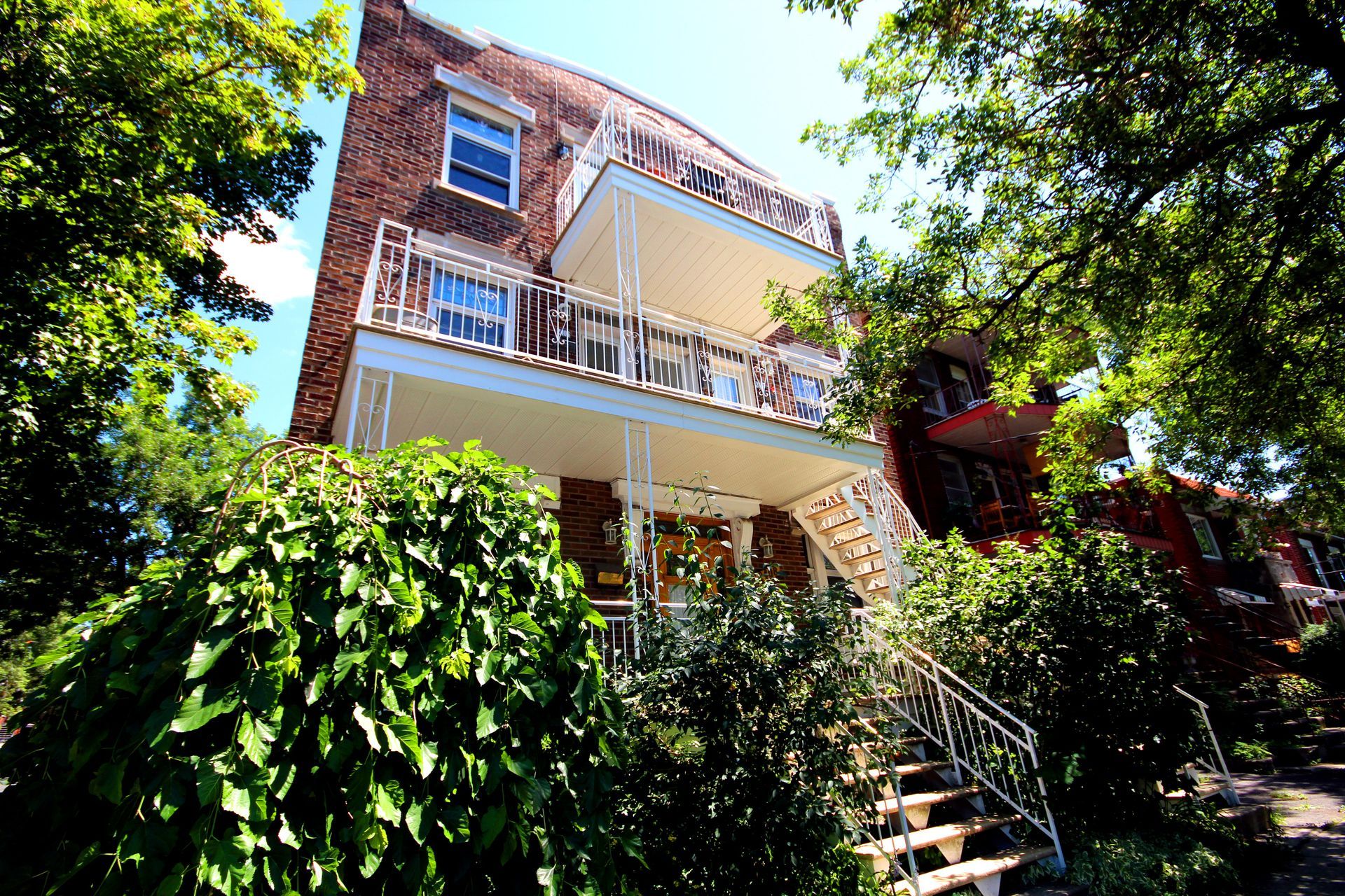 Une grande maison en brique avec balcon et escaliers
