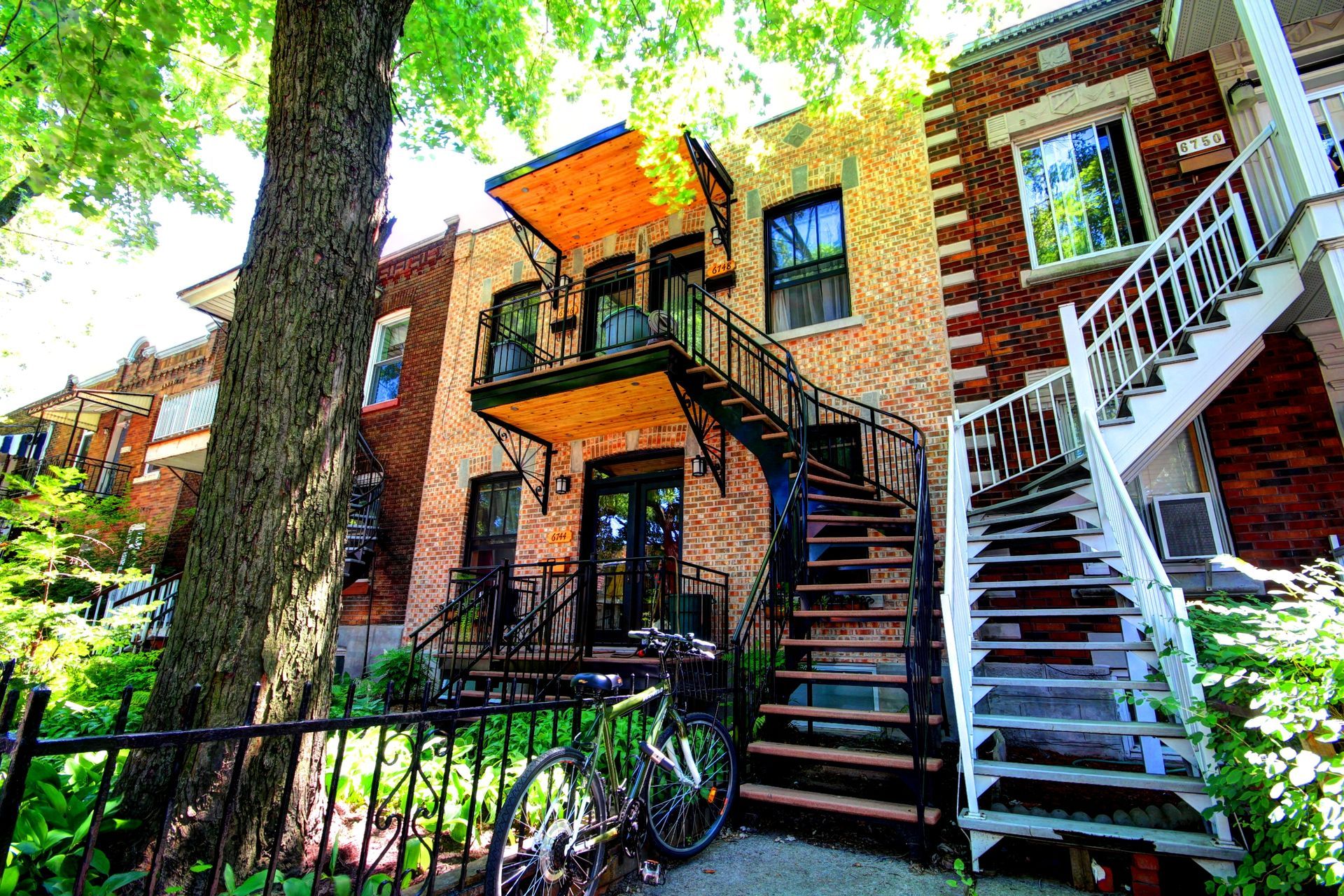Un bâtiment en brique avec des escaliers et un vélo garé devant.