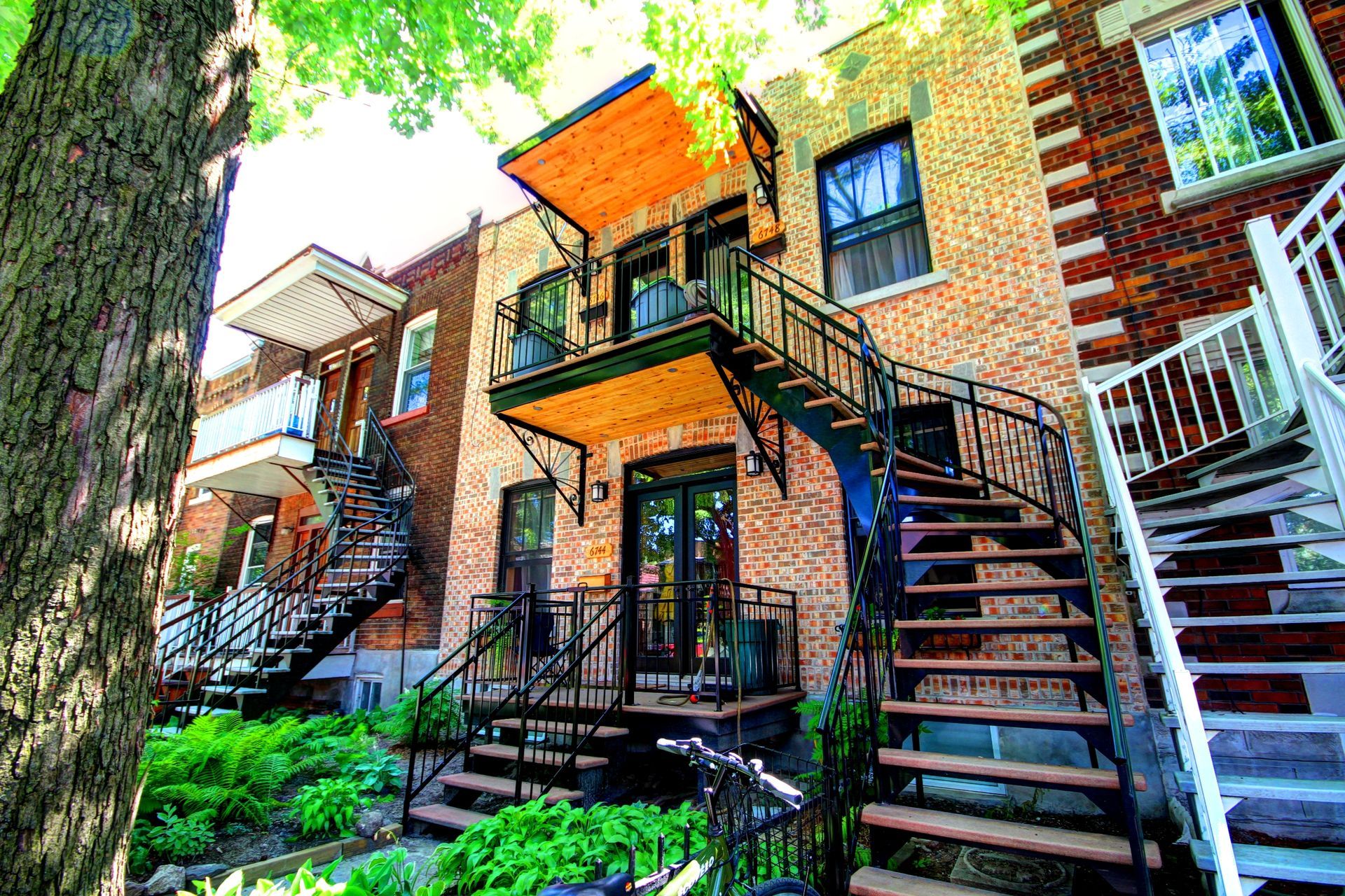 Une maison en brique avec des escaliers menant au deuxième étage.