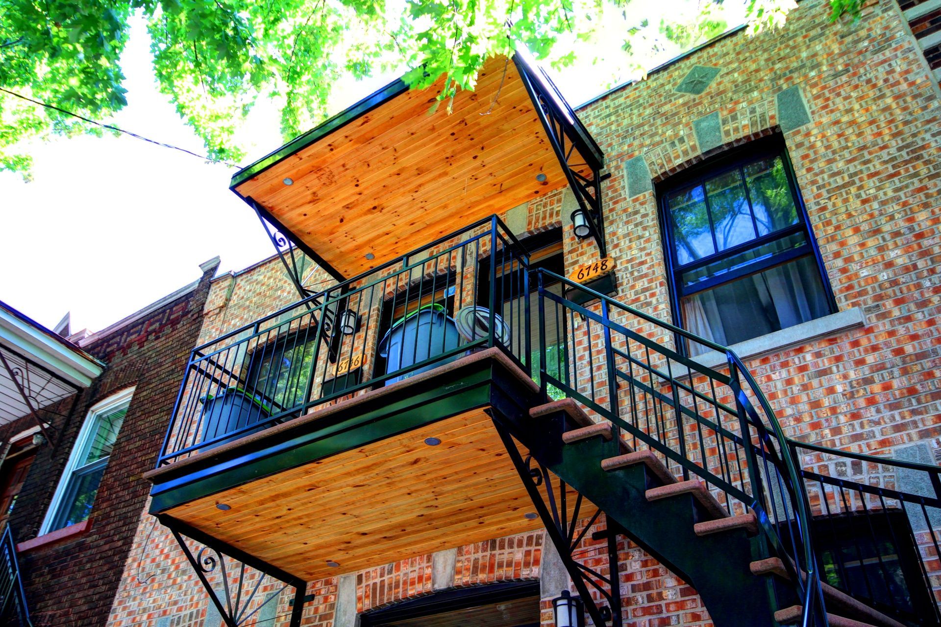 Un bâtiment en brique avec un balcon et des escaliers qui y mènent.