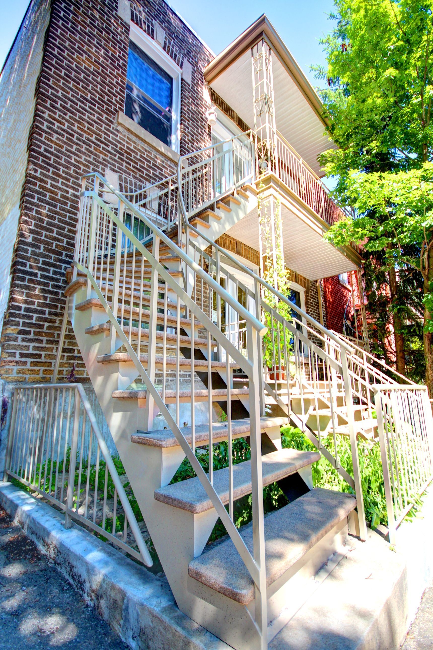 Un immeuble en brique avec des escaliers menant au deuxième étage.