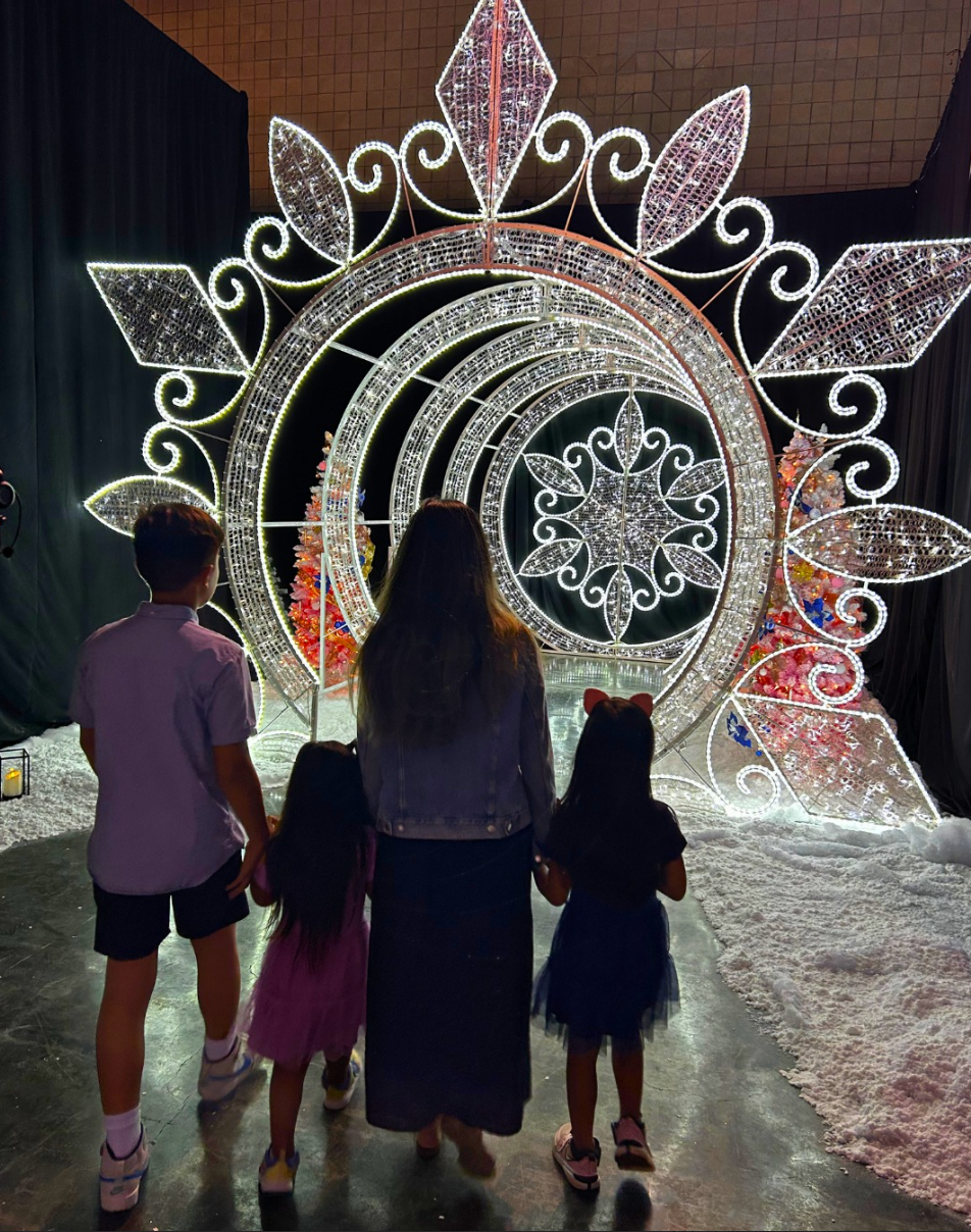 Family enjoying a holiday light display event with snow