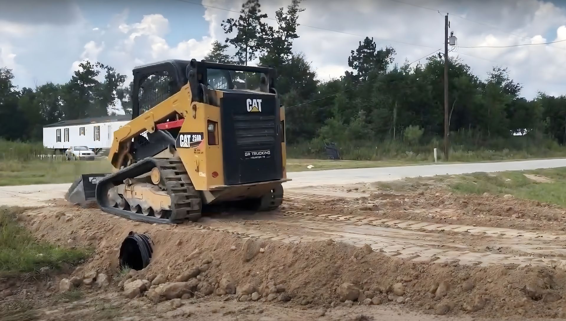 Repairing a culvert with a skid steer for a field access point.  