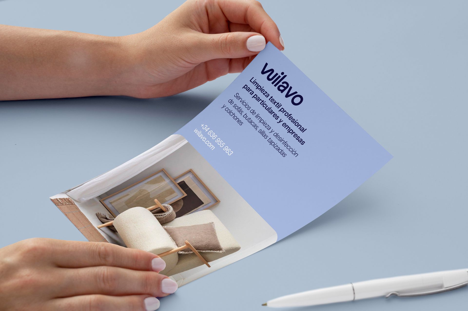 Una persona té un fulletó a les mans al costat d'un bolígraf. Wilavo