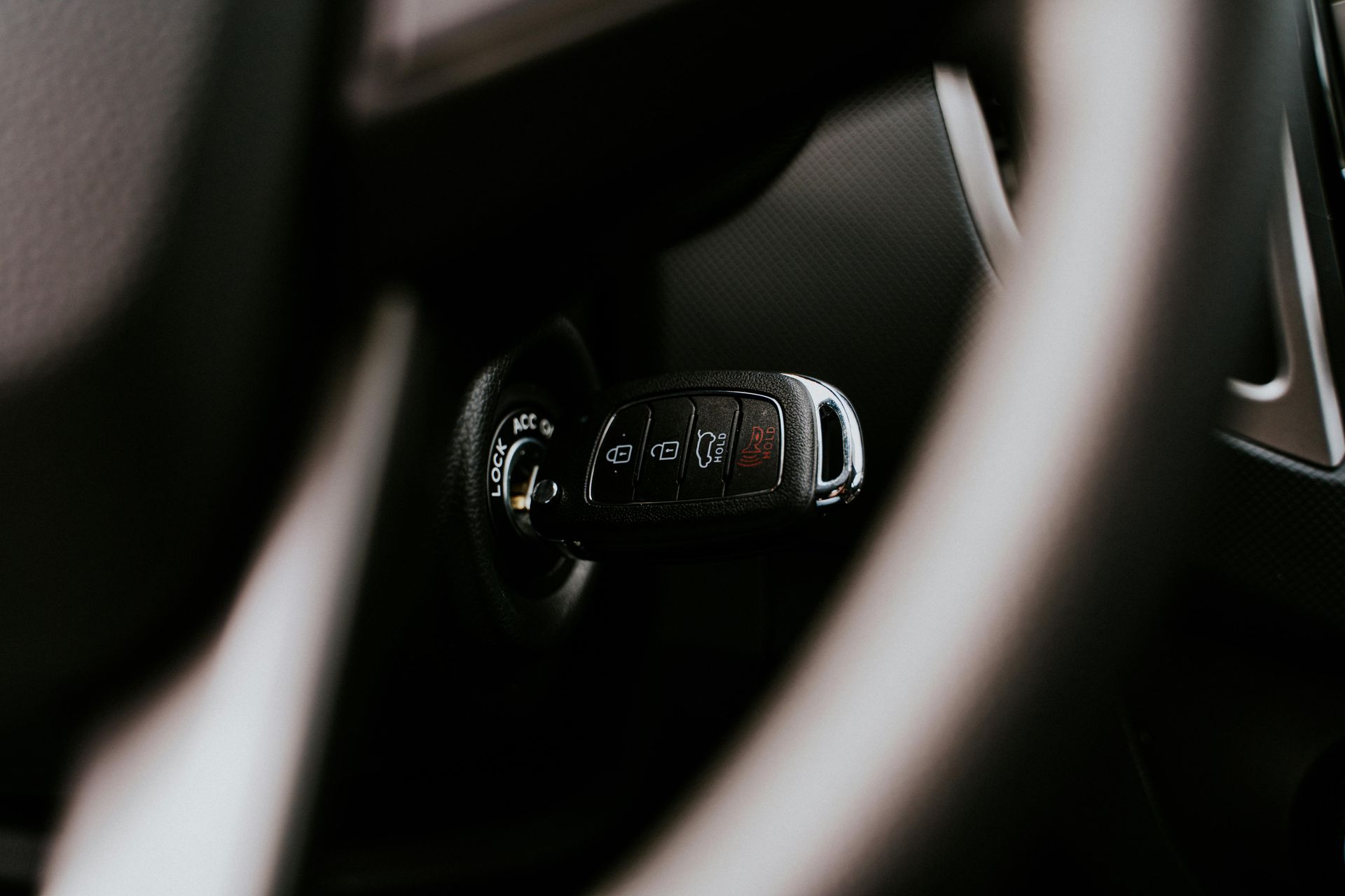 A close up of a car steering wheel with a key in it.