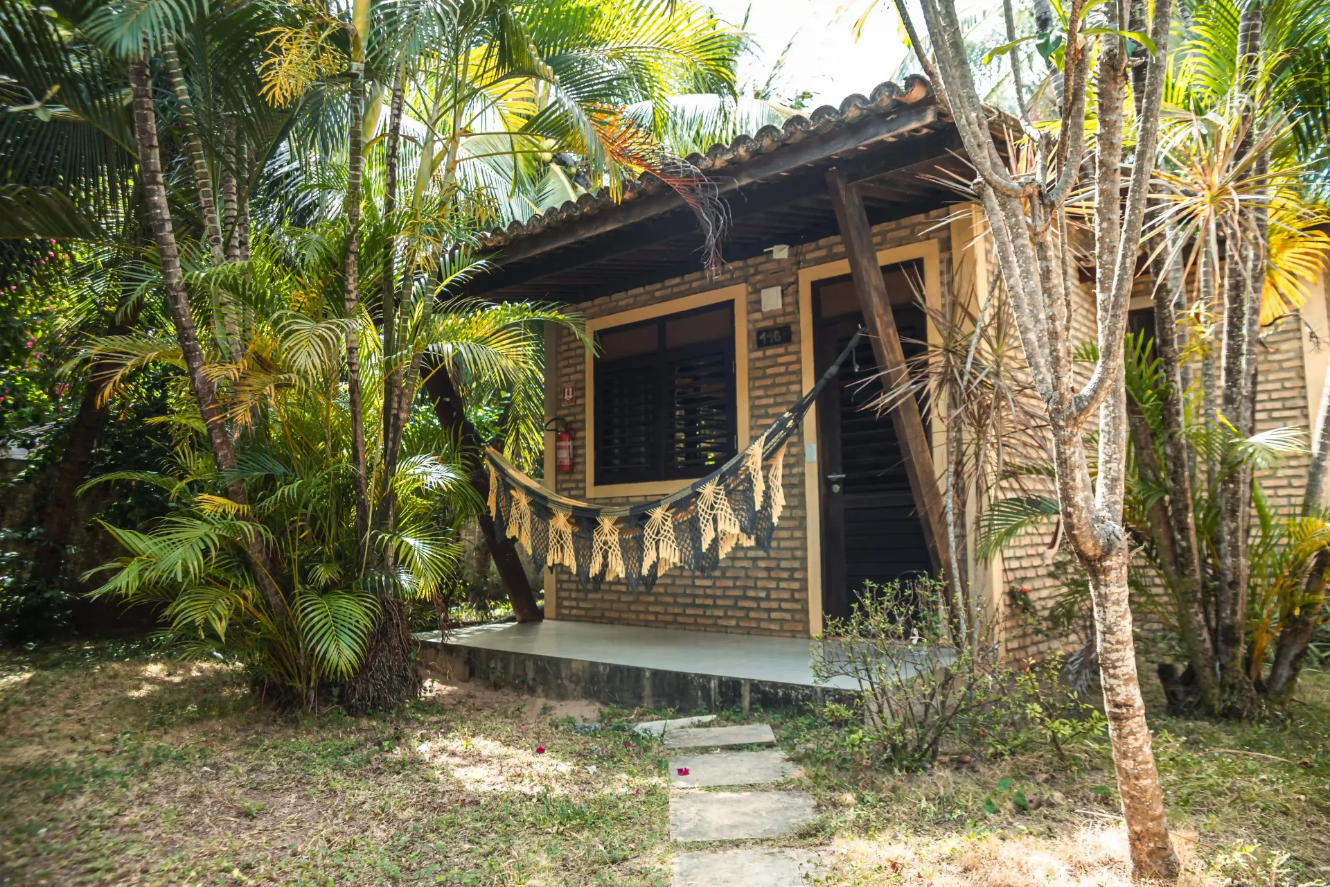 Uma pequena casa de tijolos no meio de uma floresta cercada por árvores.-Pousada-Imperio-do-Sol
